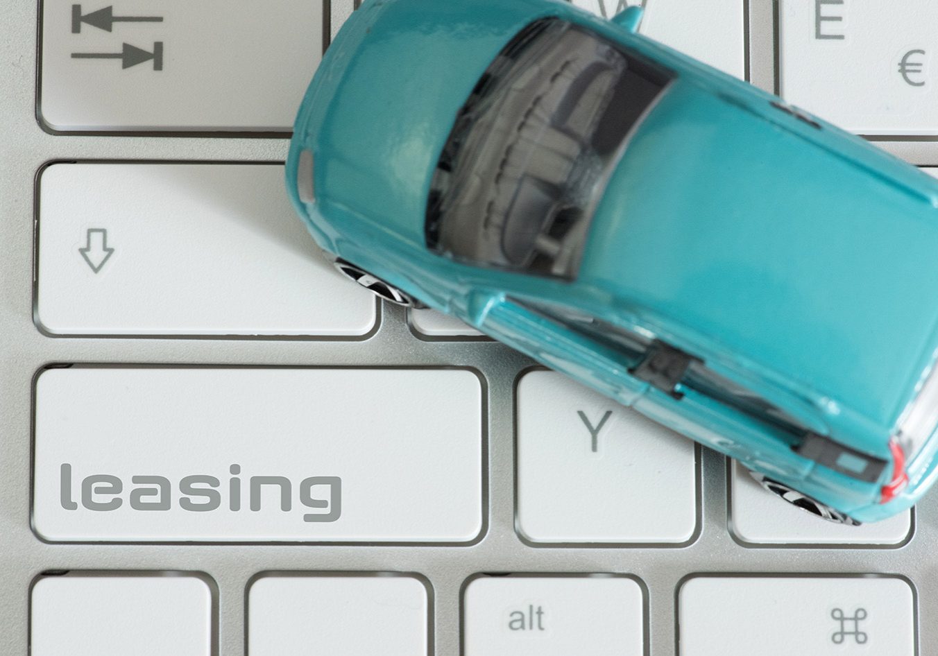 Ein Computer, Auto und die Taste für Leasing